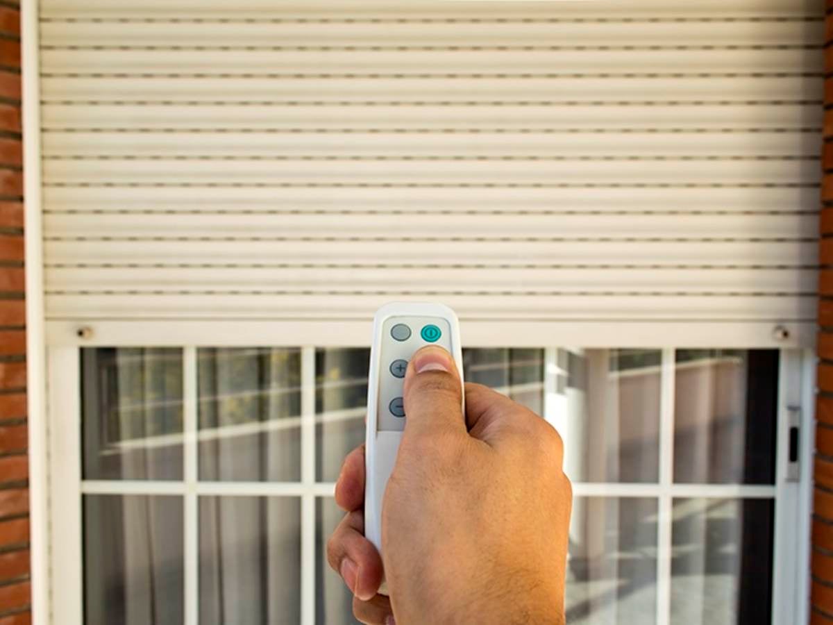 hand holding remote in front of a window