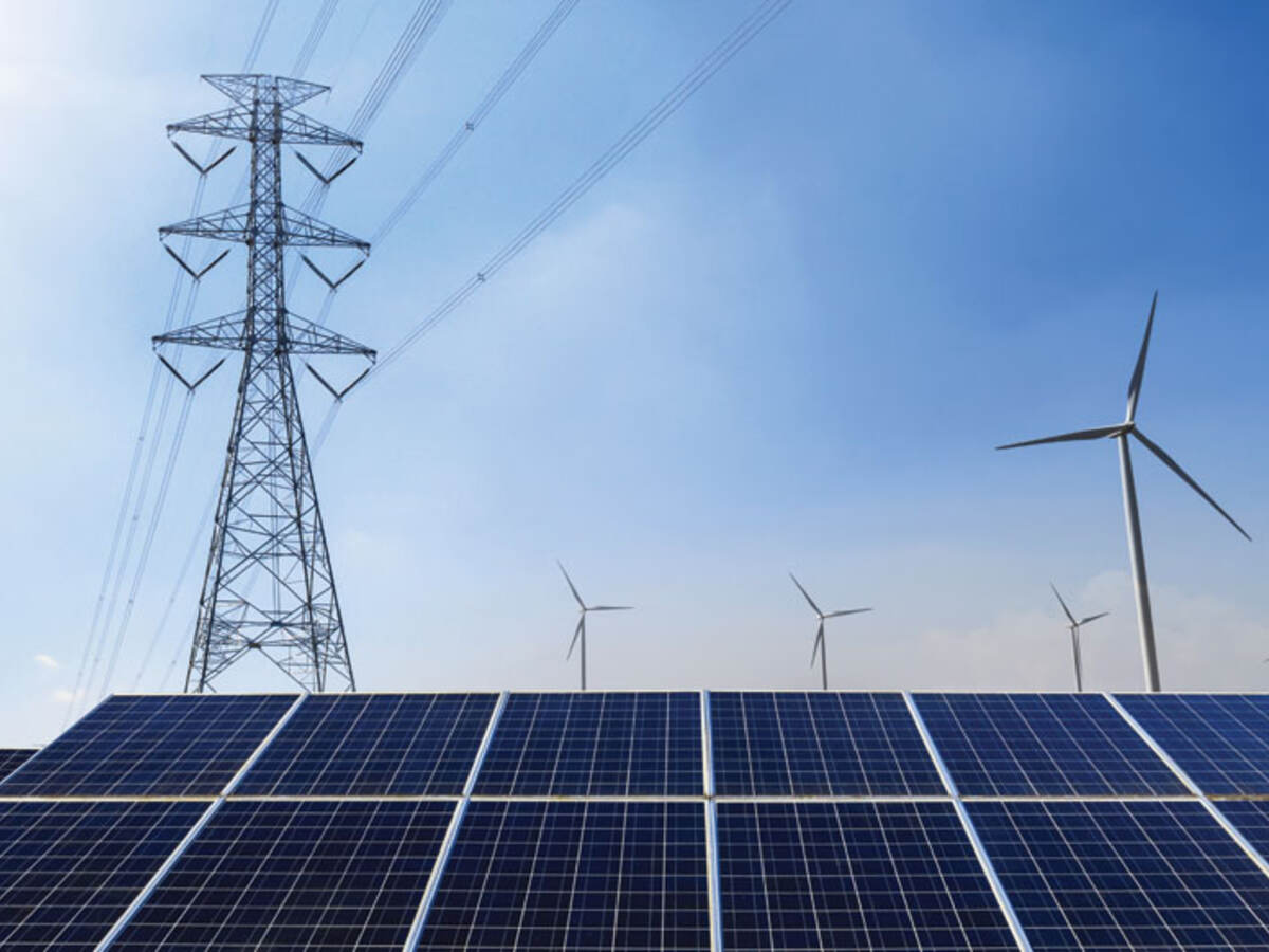 Power line, solar panels and wind turbines against blue sky