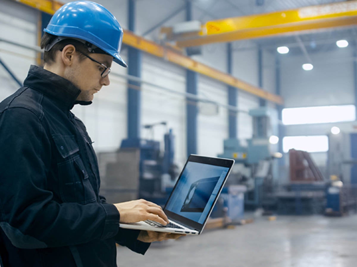 Worker in a hardhat using a laptop