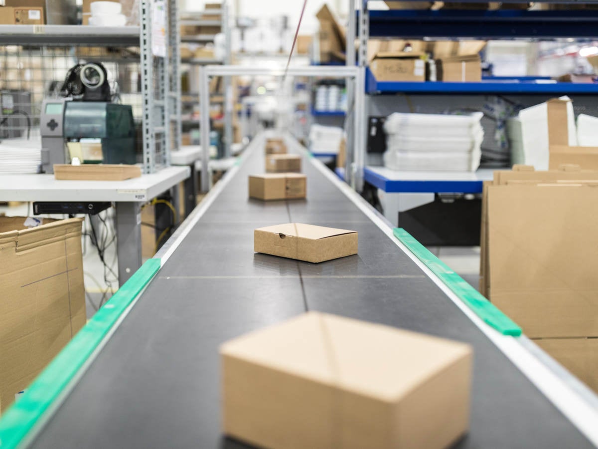 Cardboard boxes on conveyor belt at distribution warehouse