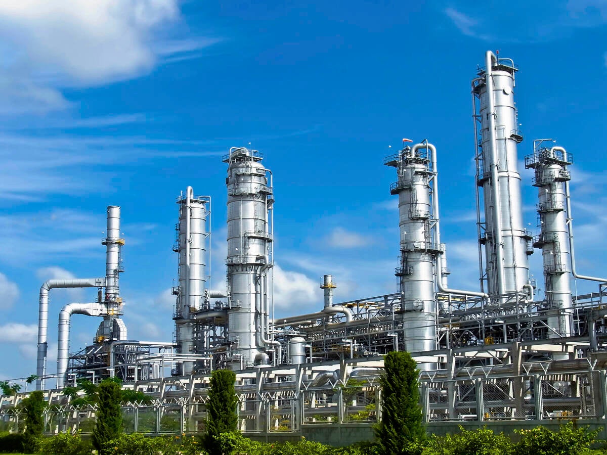 Energy processing facility against a blue sky with drifting clouds