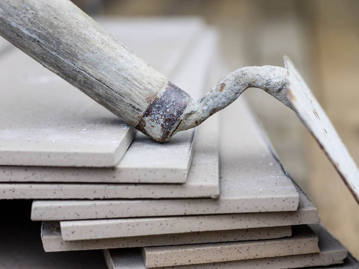 A trowel rests casually on a stack of cement tiles.