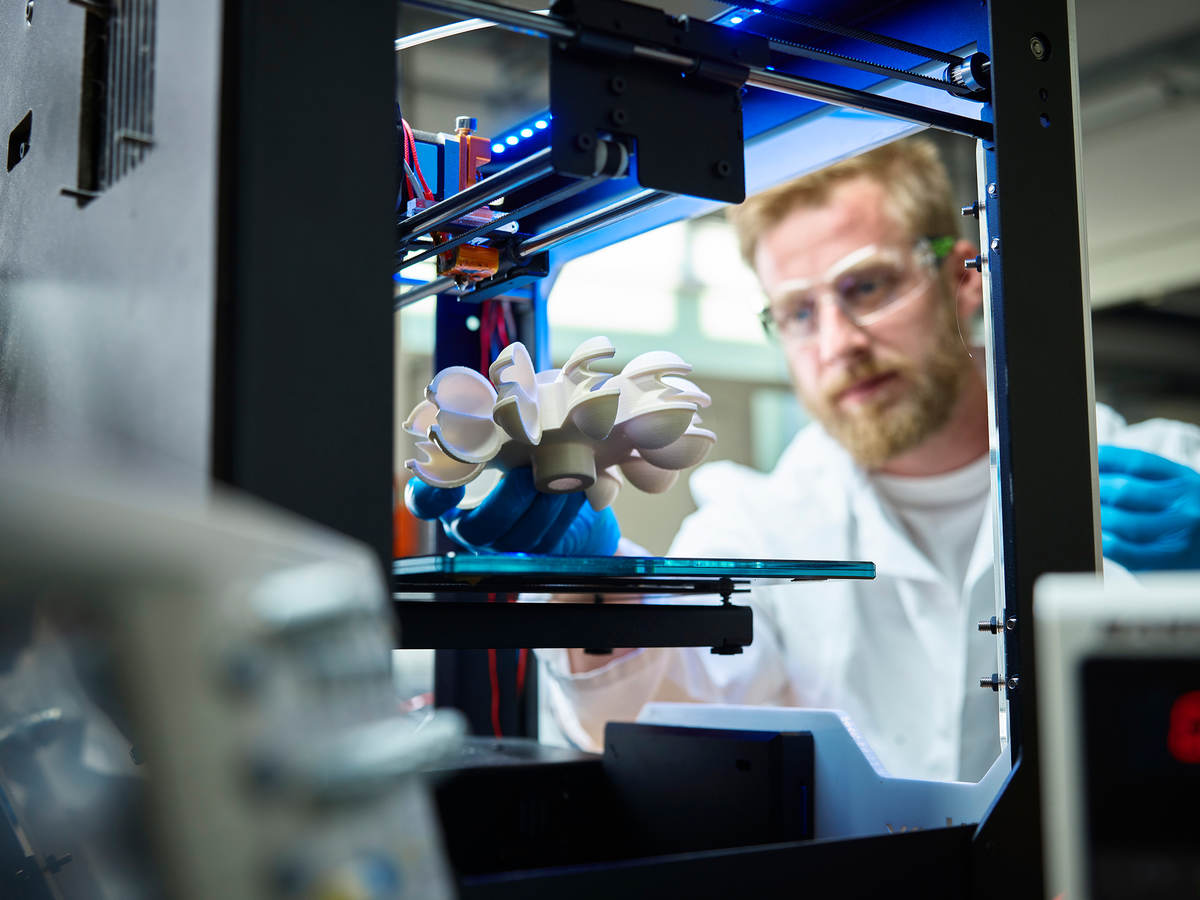 Photo of a scientist testing 3D printed plastic object