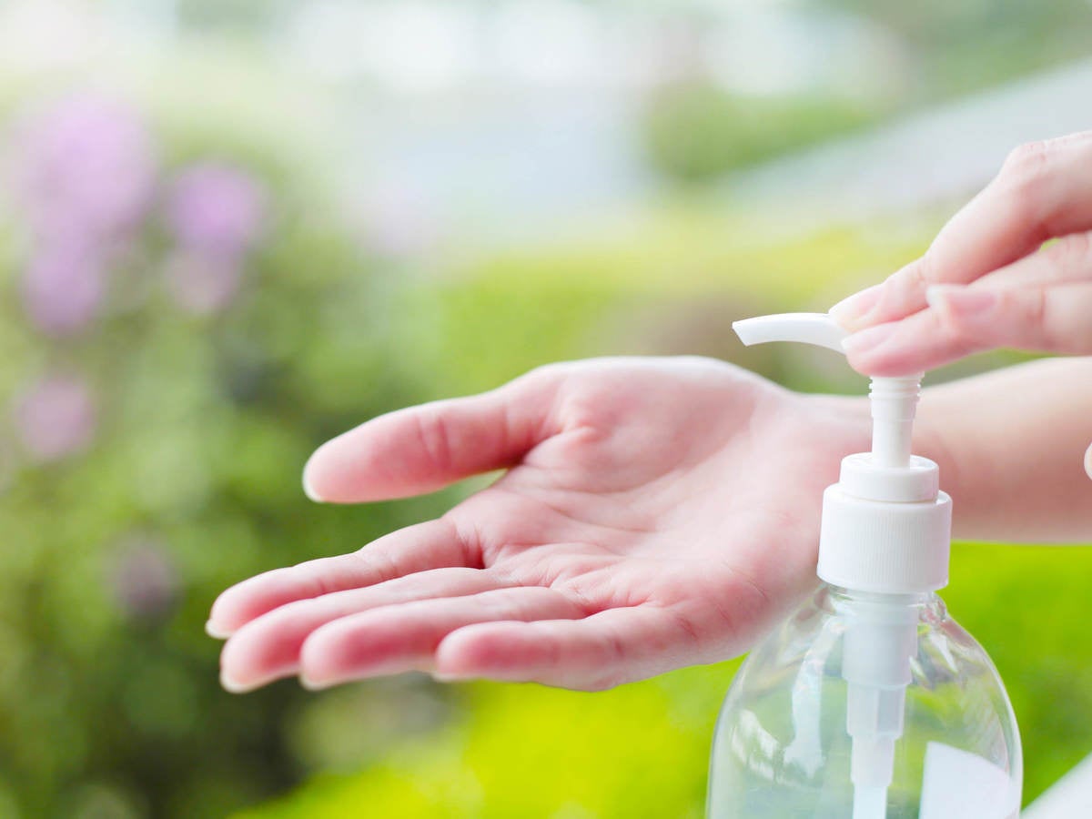 Female hand dispensing hand sanitizer onto open palm