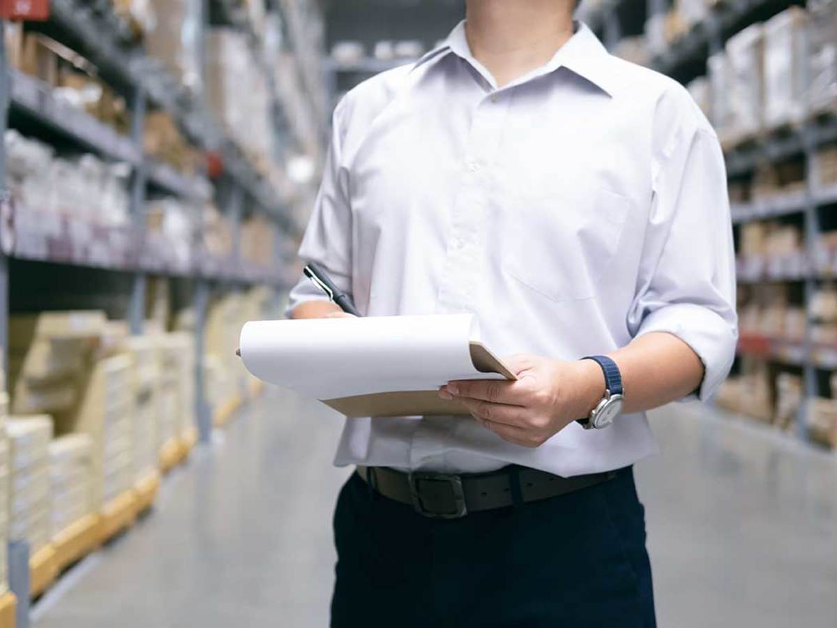 Man checking items on a clipboard in a warehouse