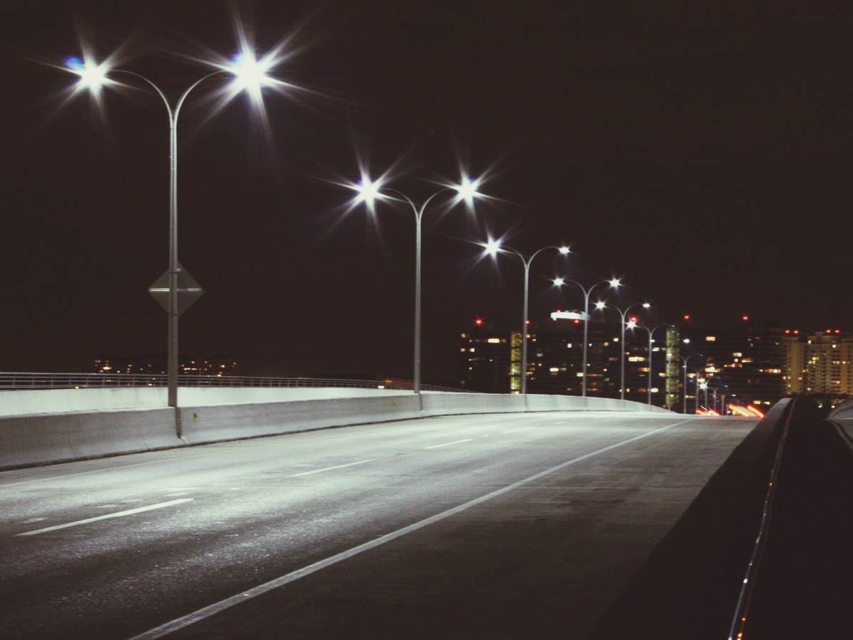 Streetlights at night on quiet road. 