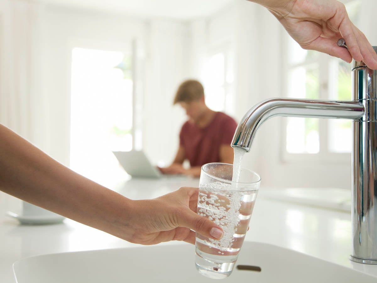 Person filling a glass with water