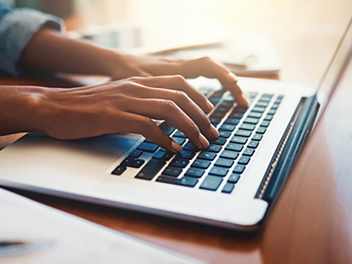 Photo of a person typing on a laptop