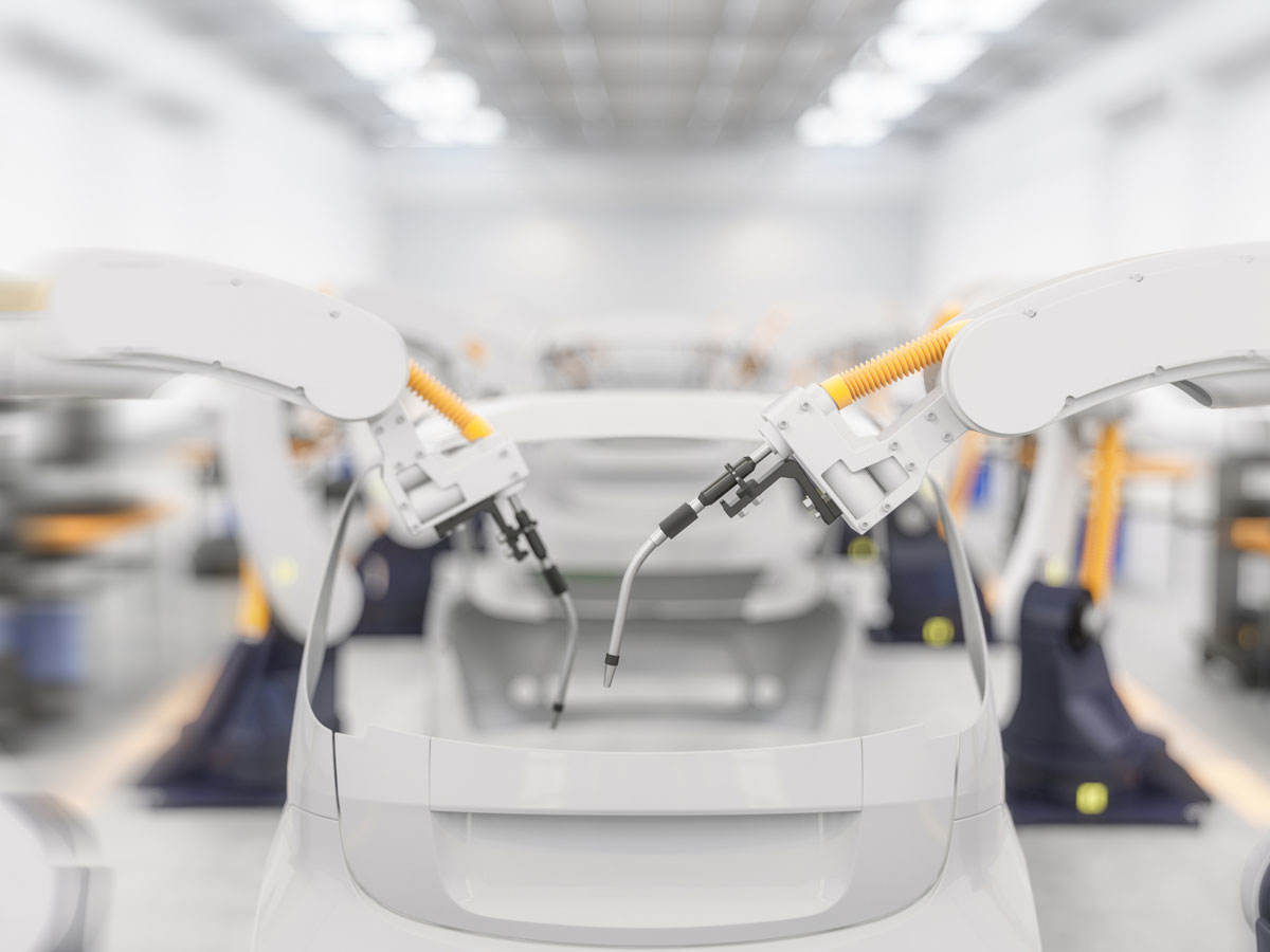 Car being built on assembly line in factory with robot arm adding parts to car