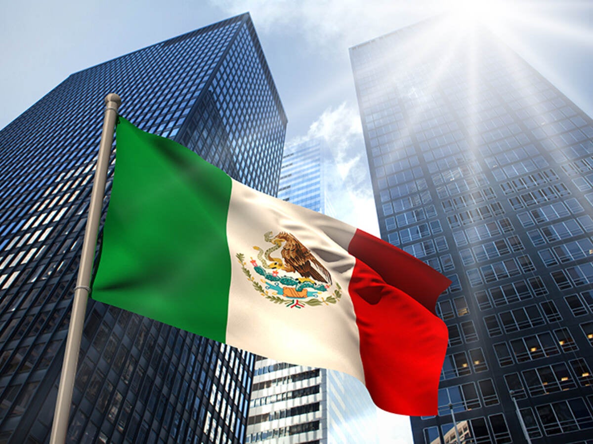 Mexico flag in front of tall sky scrapers