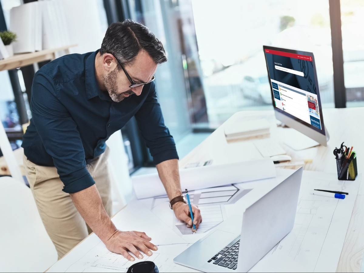 Man at desk looking at computer with Product iQ on screen. 