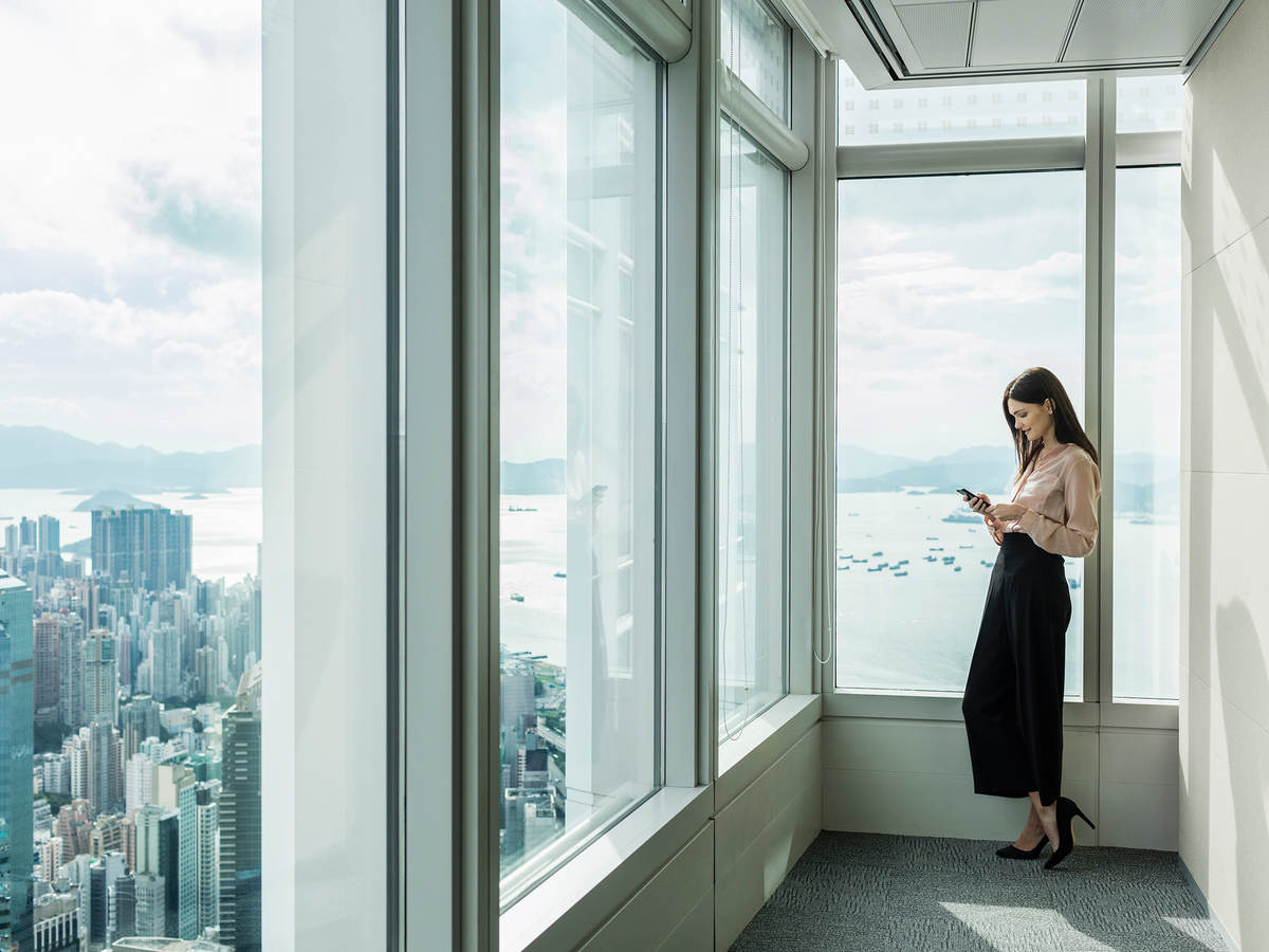 Woman reading near large windows