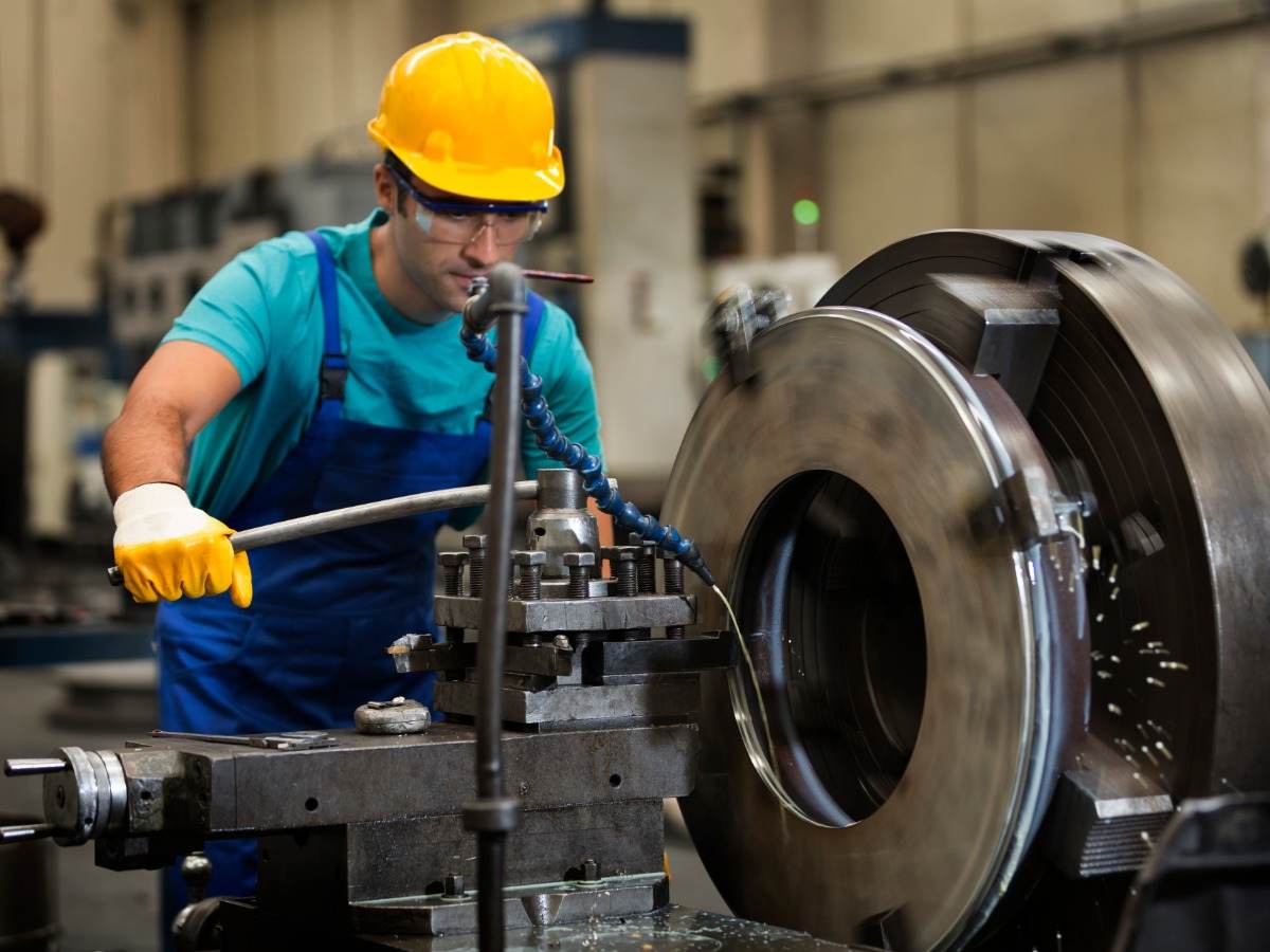 Man using metal cutting machine in factory