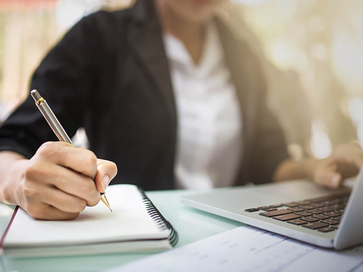 Photo of a person writing in a notebook