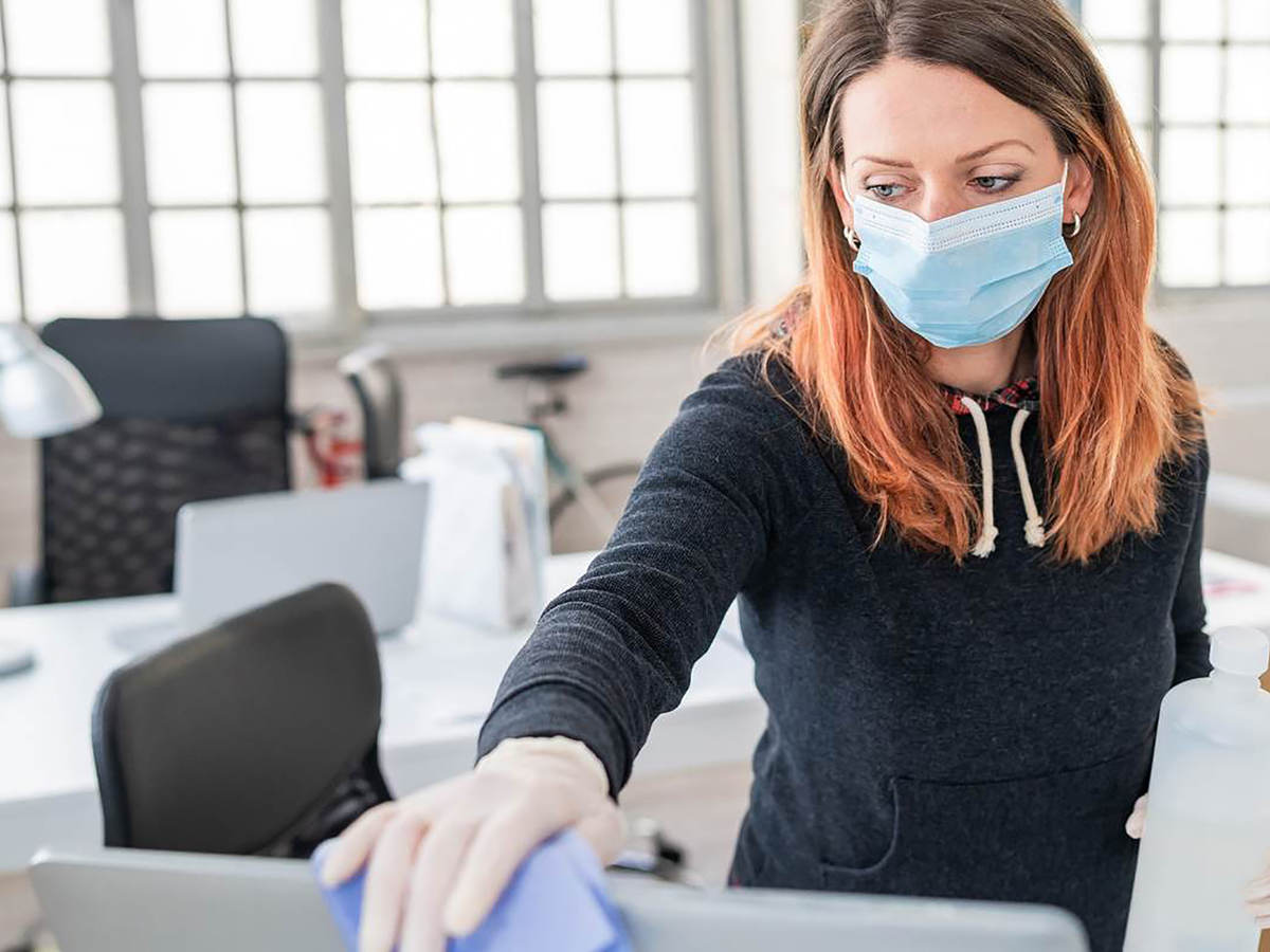 Photo of a woman cleaning a monitor