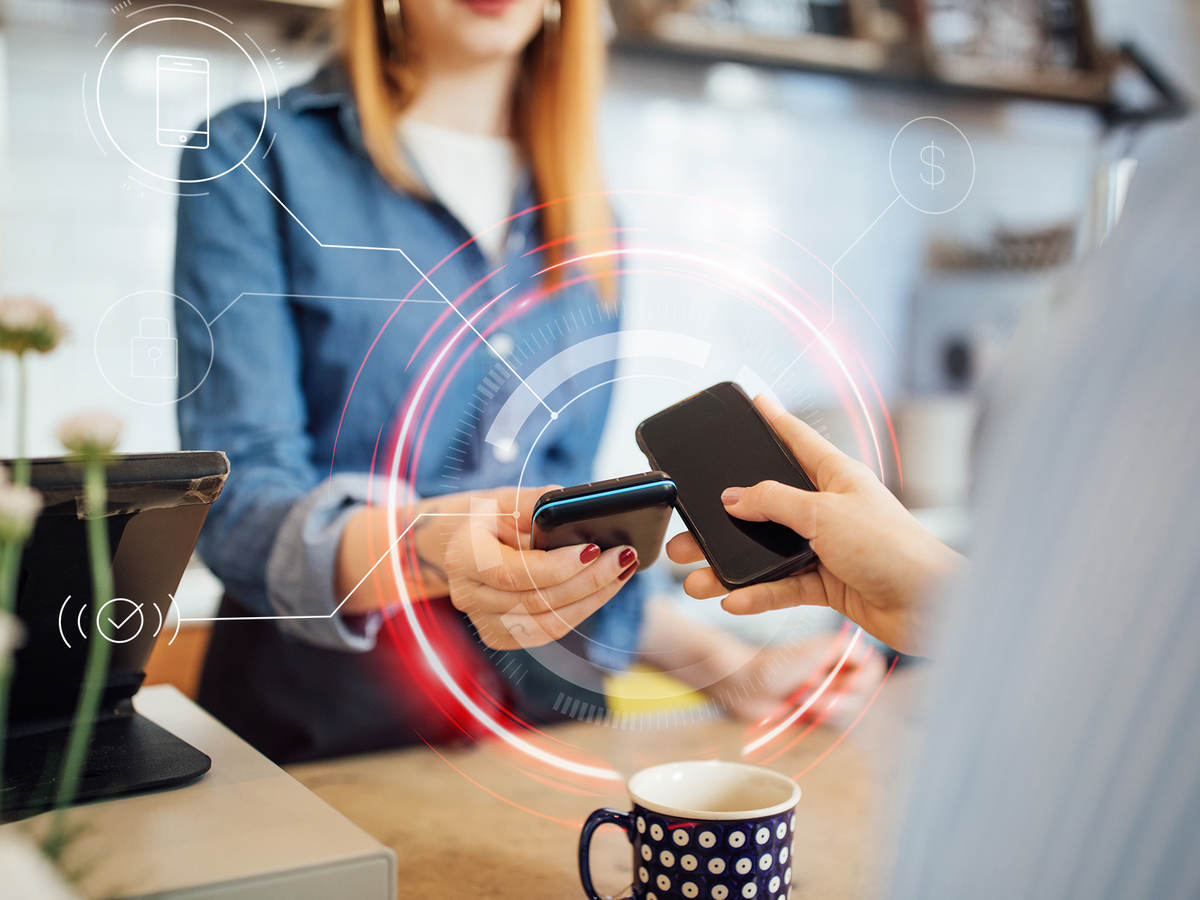 Woman tapping smartphone with another smartphone for payment