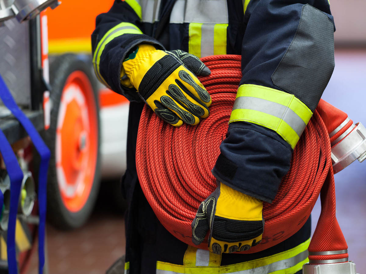 Photo of a firefighter holding a firehose