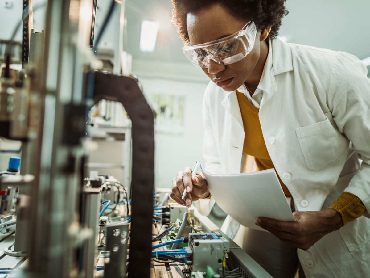 Female engineer working on industrial machine in laboratory 