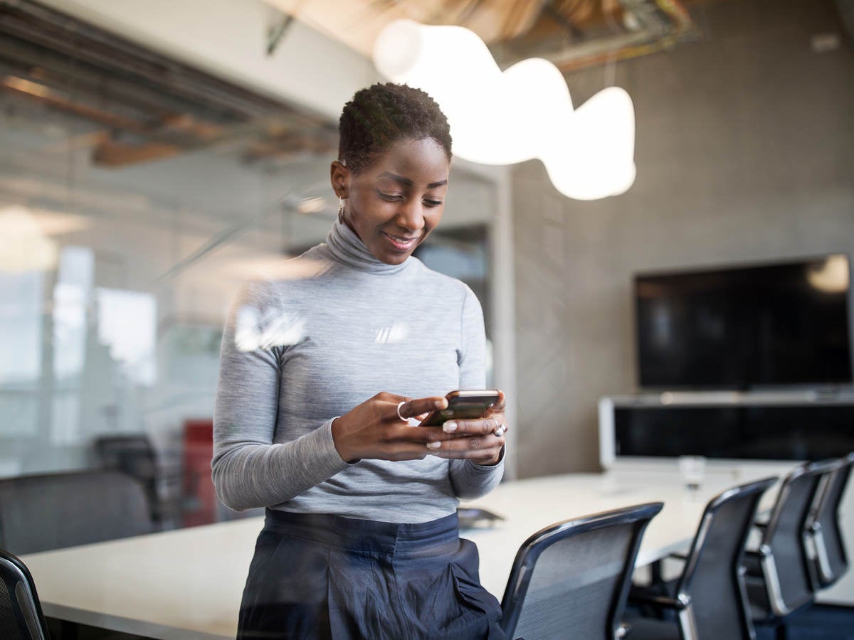 Business woman using cellphone in office to make payment