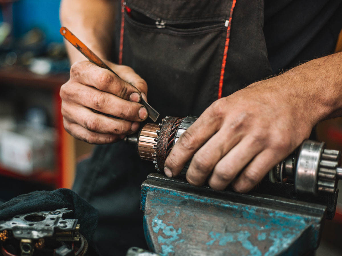 Manual worker repairing electric motor in a workshop