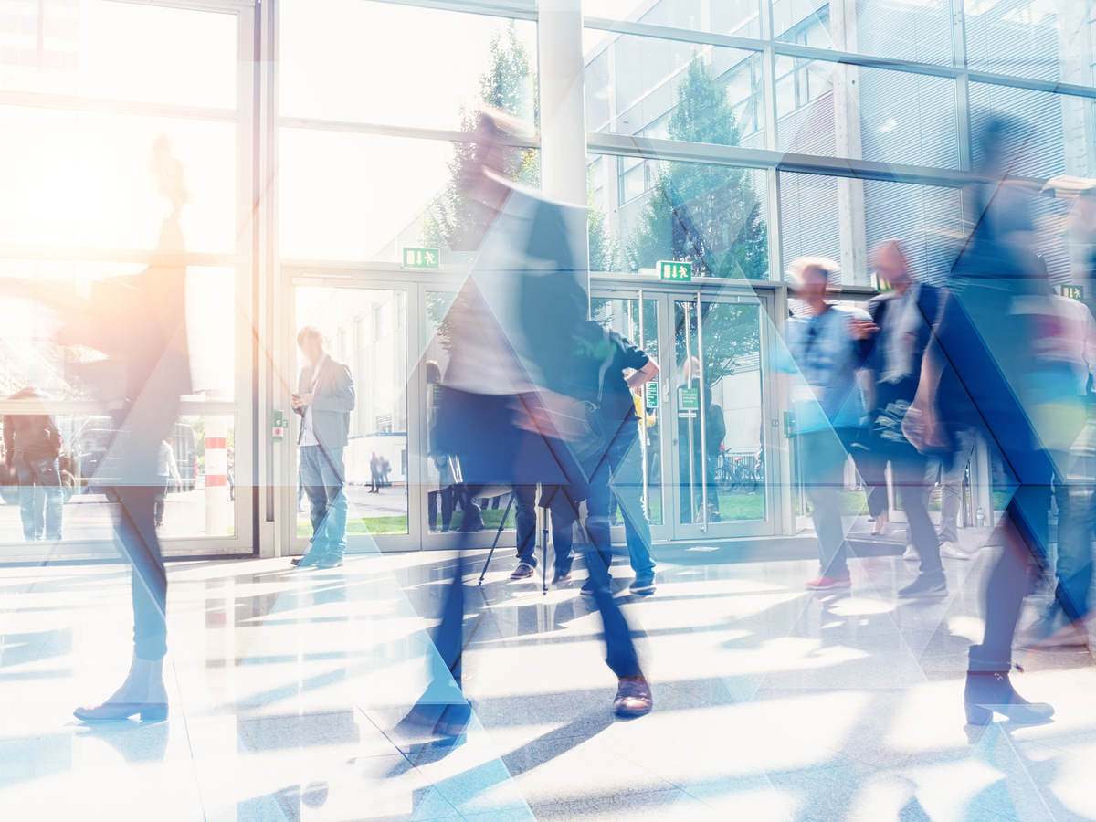 Business people walking in the lobby of a building with glass windows