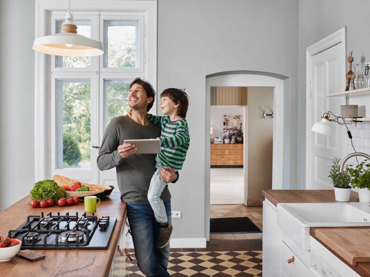 Father and son switching on smart lighting in the kitchen