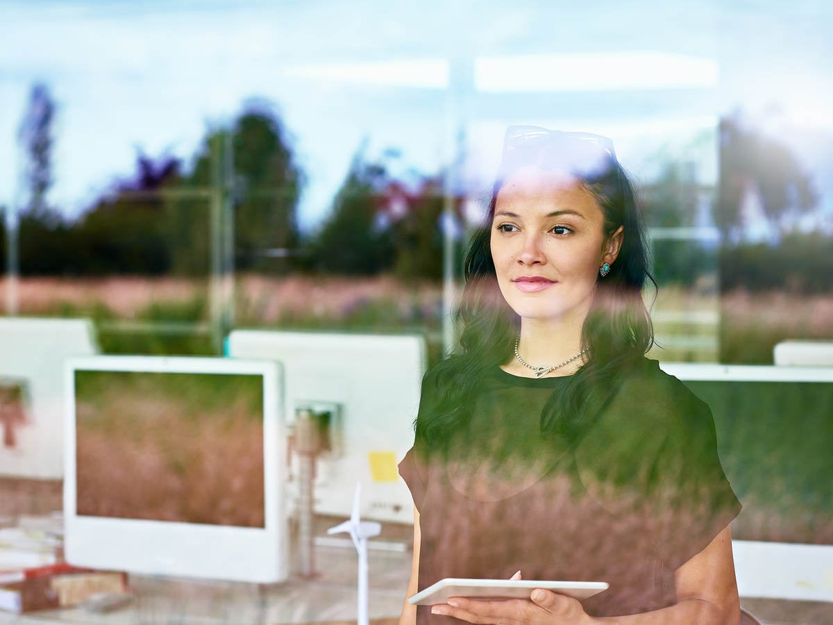 Woman looking outside a window at work 