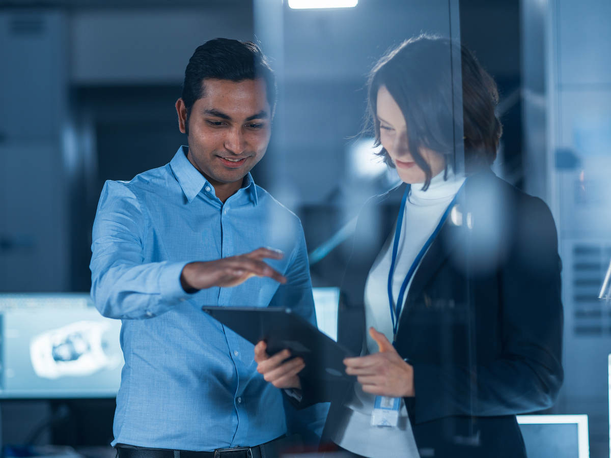 A man and woman looking at a digital tablet