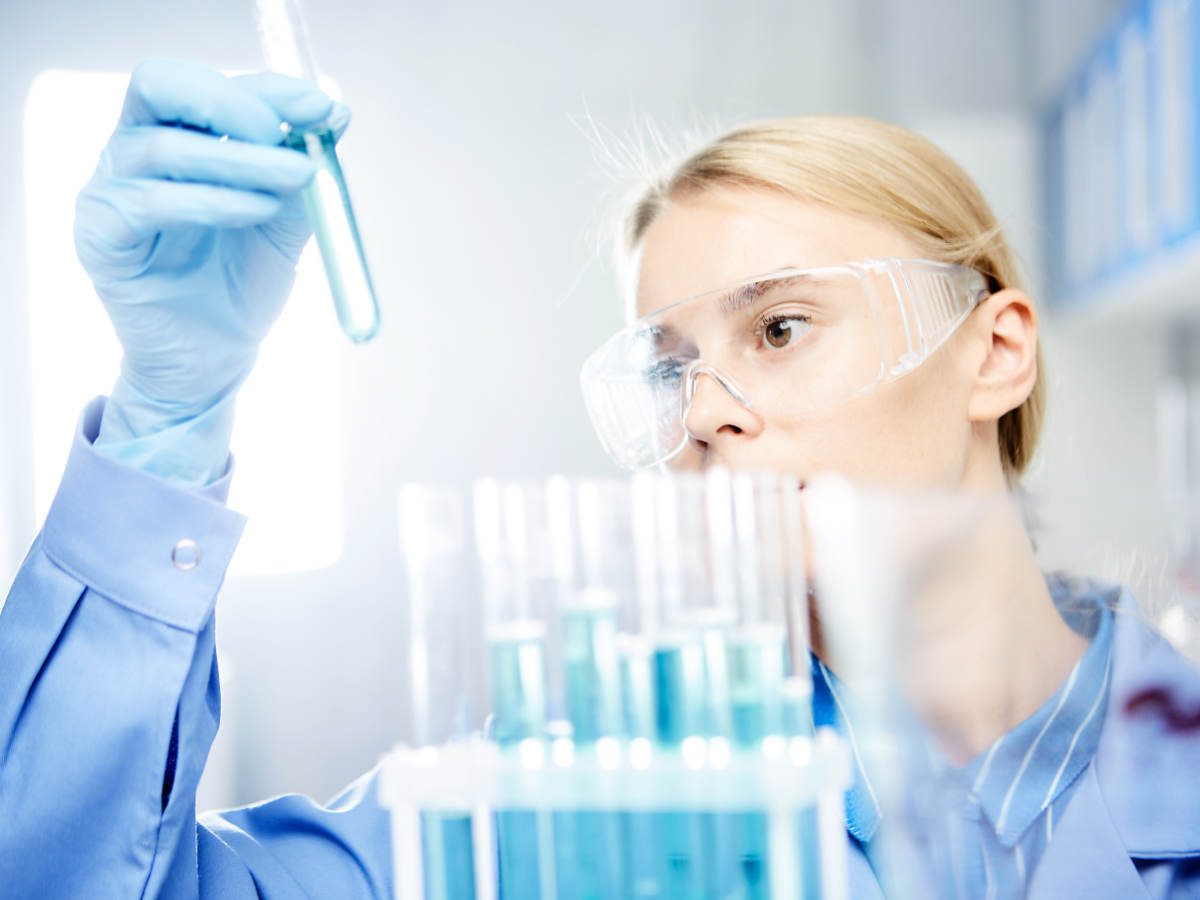 Young woman working in laboratory, handling test tubes