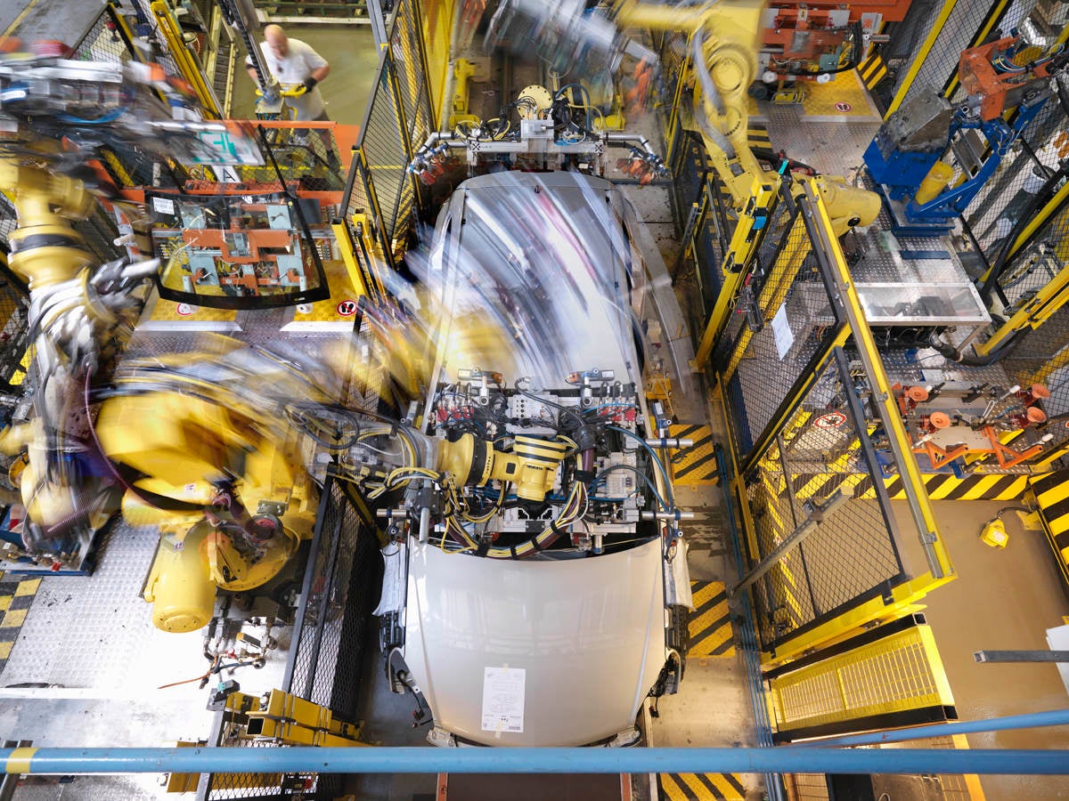 Machine working on car in plant