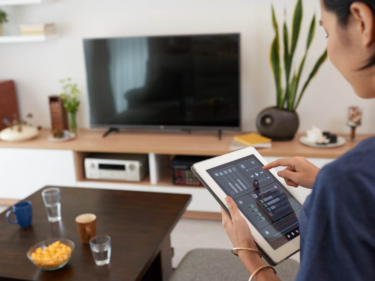 Woman controlling a smart home system with a tablet 