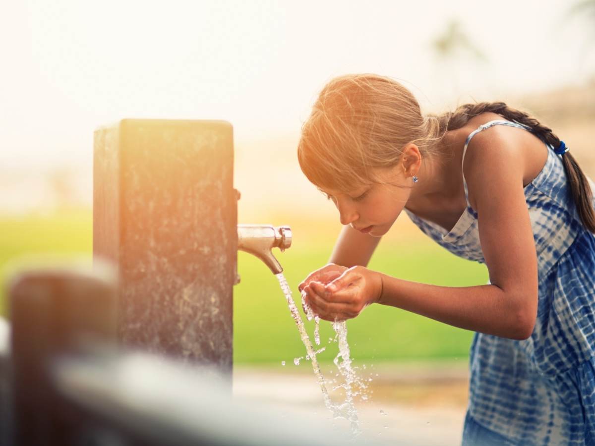 Girl drinking water from fountain