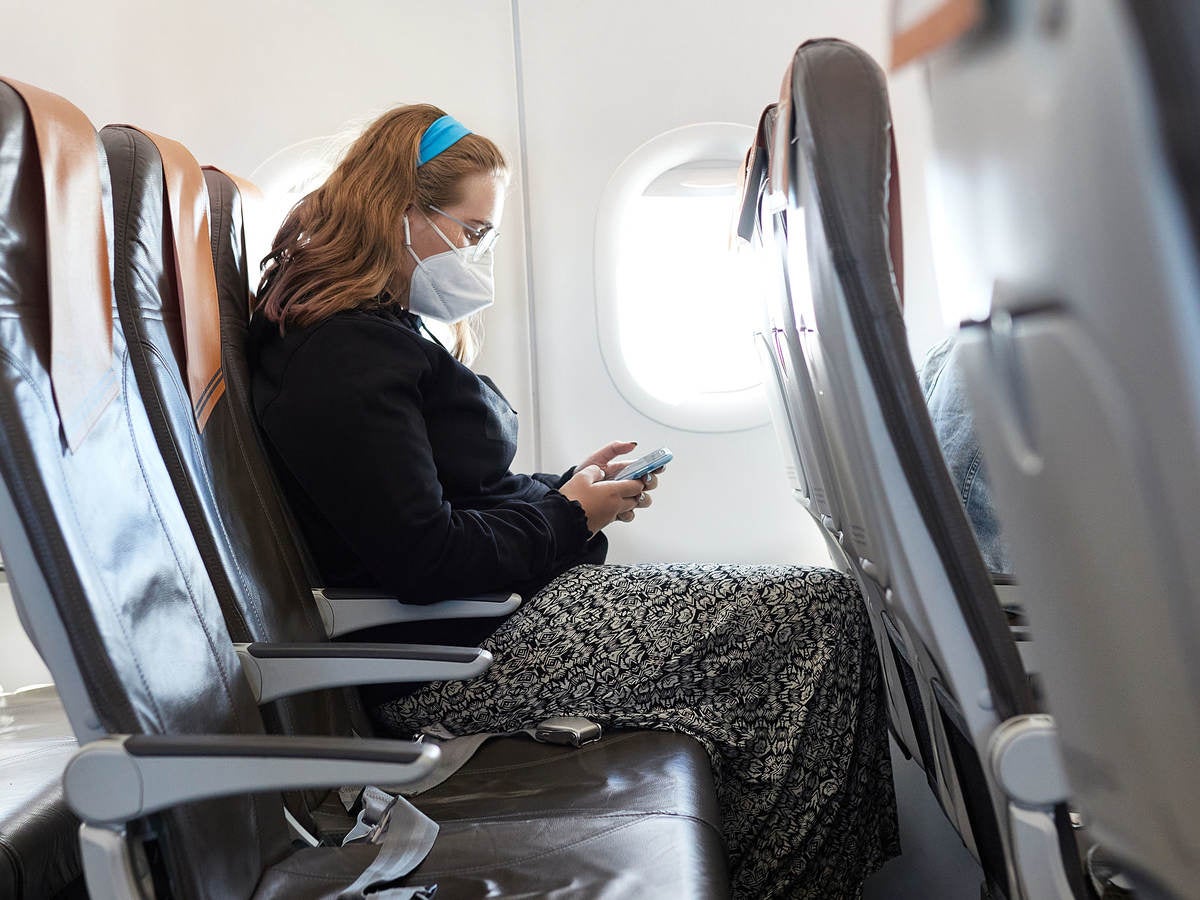 woman with cellphone on a plane that has lithium-ion battery