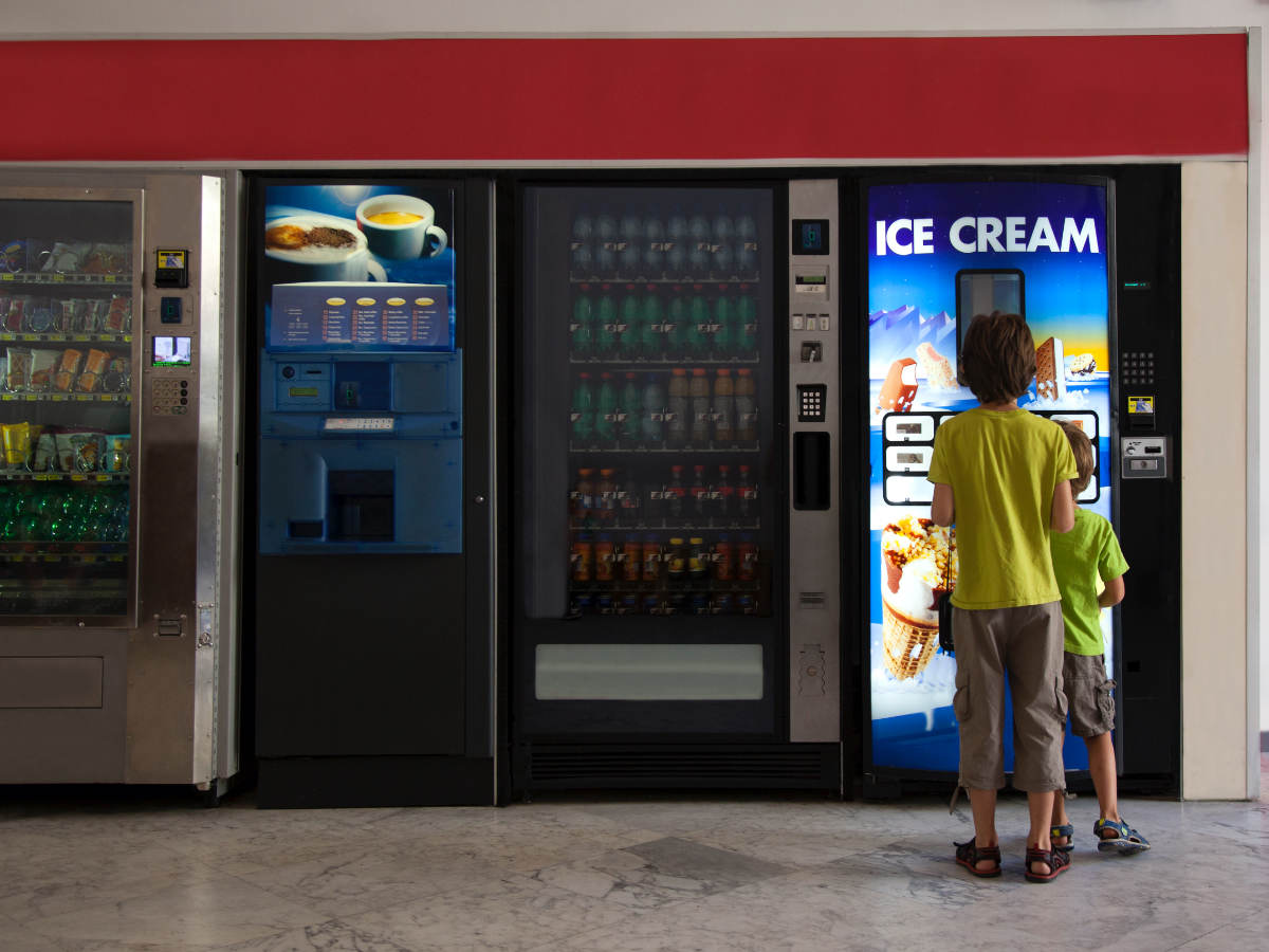 Children standing in front of a refrigerated vending machine