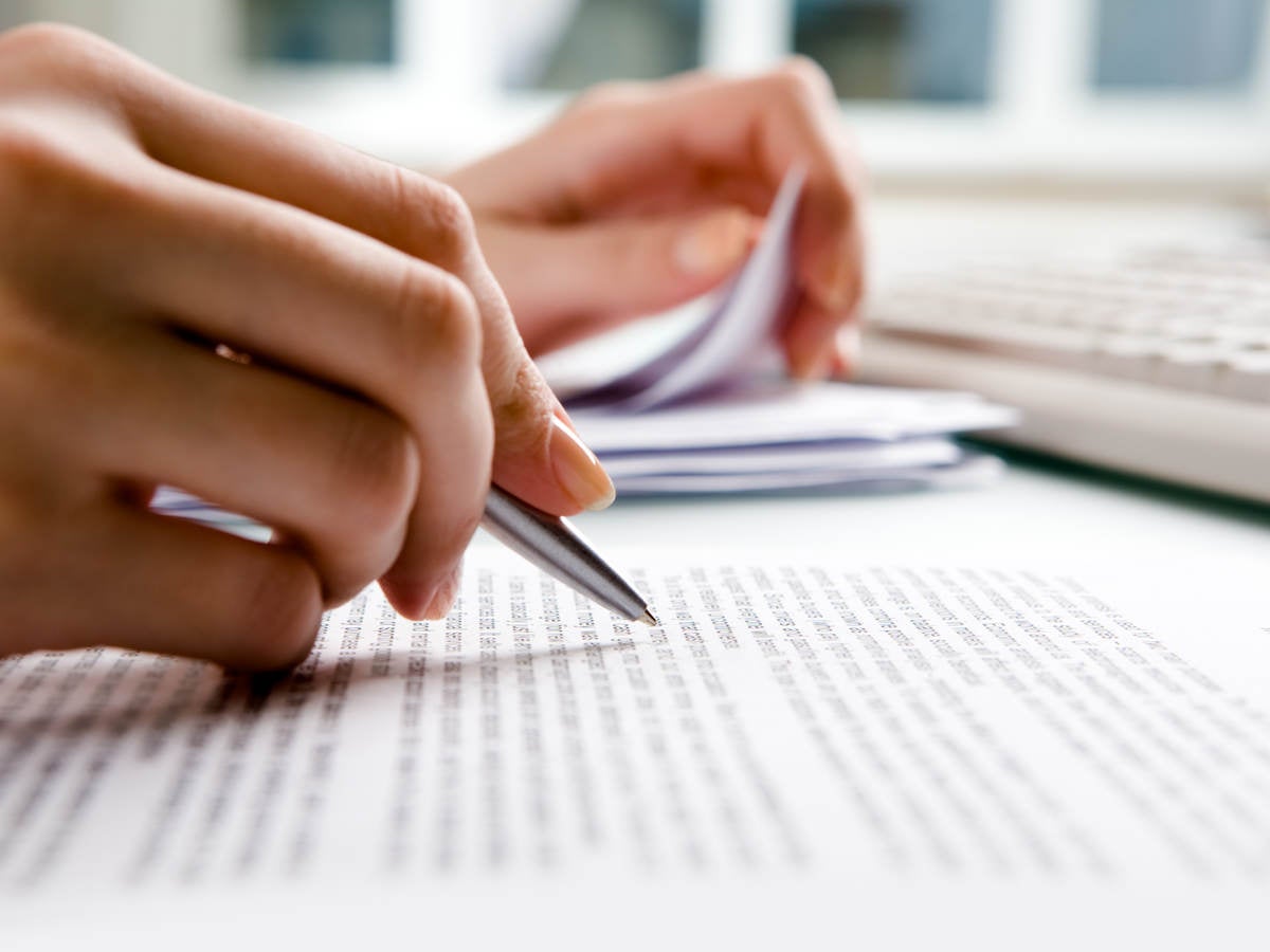 Hand holding pen writing notes. 