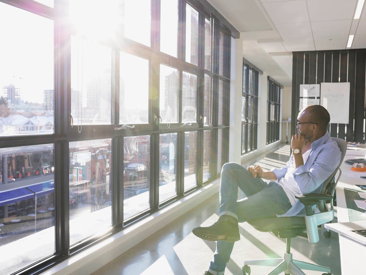 Man sitting in office looking out window. 