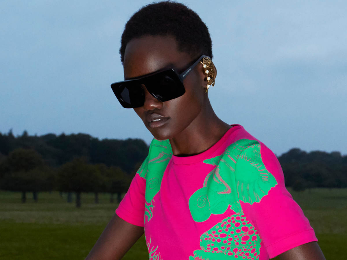 Woman wearing pink and green dress and sunglasses