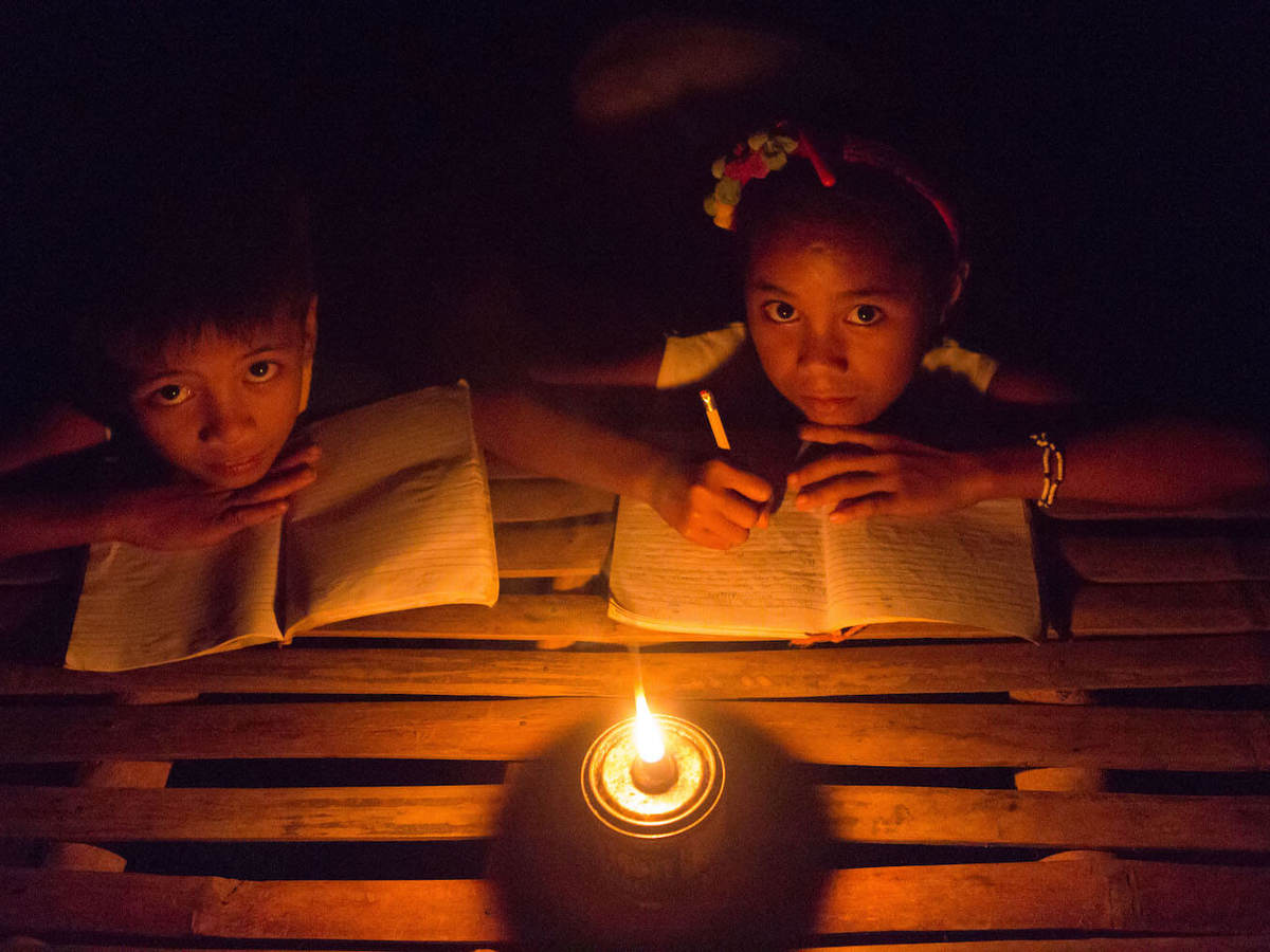 Children studying by kerosene lantern