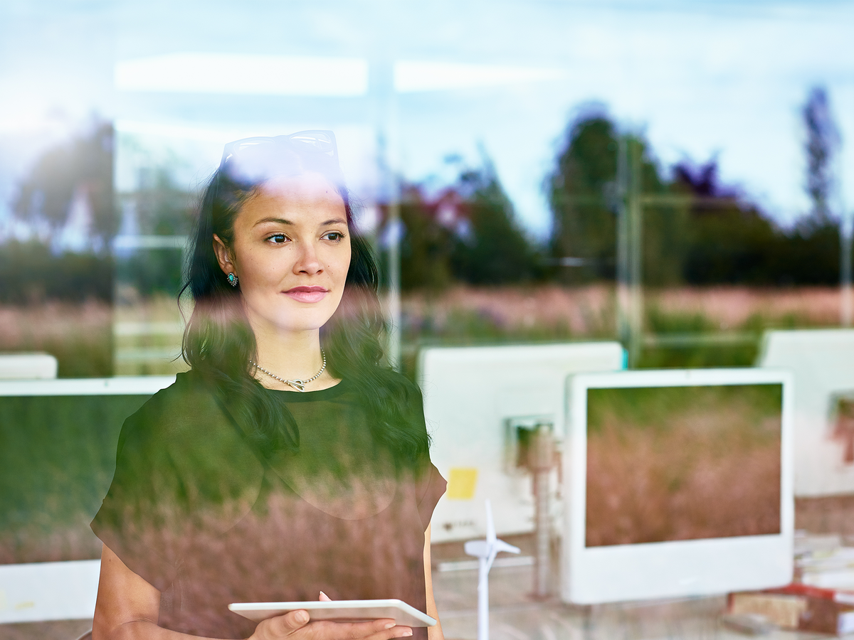 A woman views outside with computers behind her