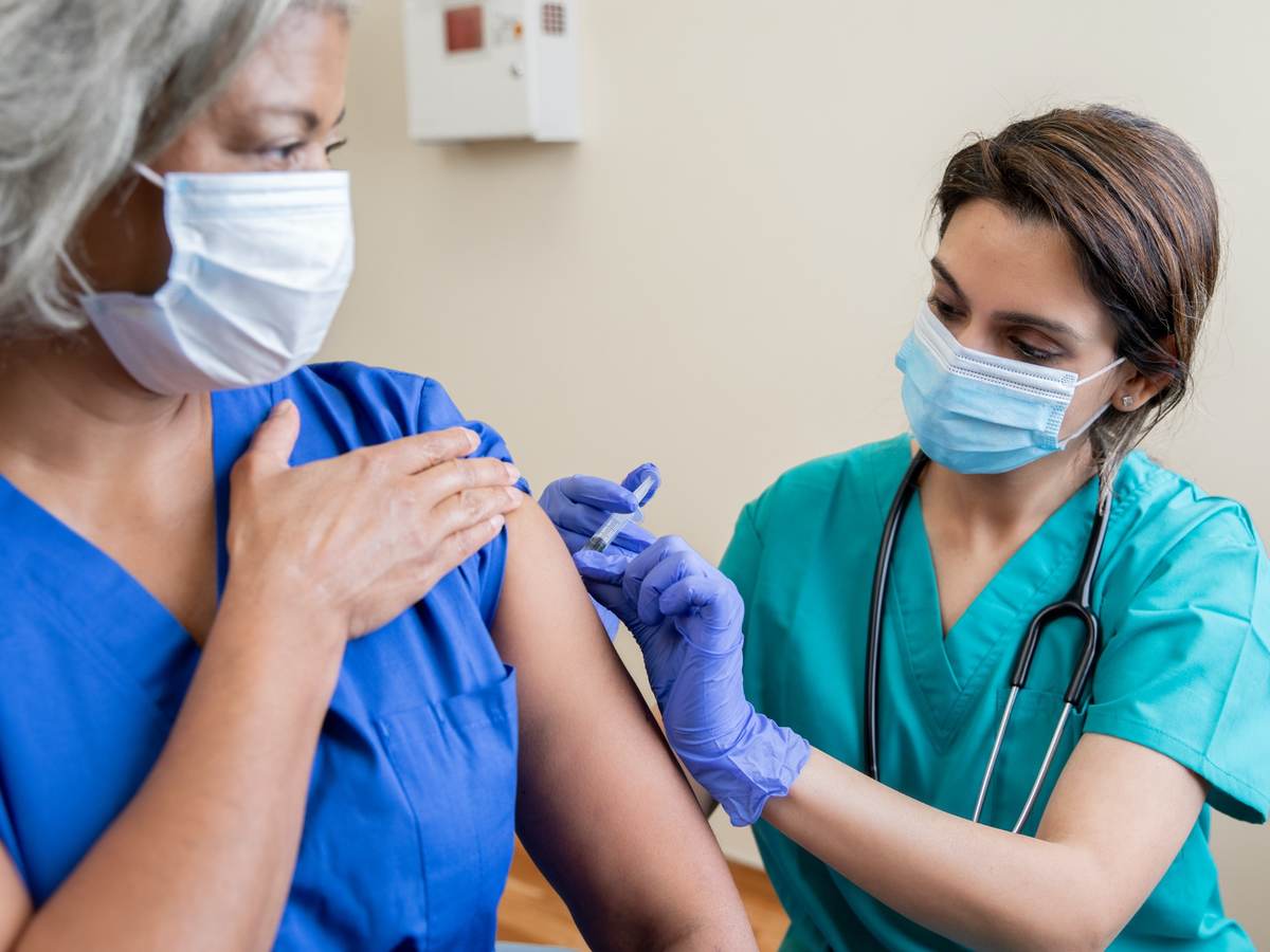 Nurse provides vaccine to elderly woman