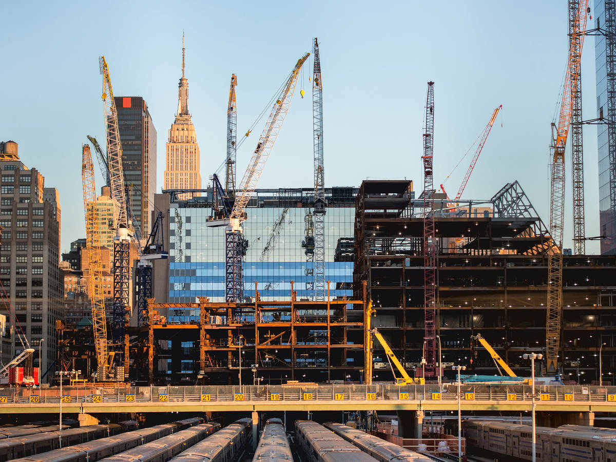 Glass office building surround by cranes