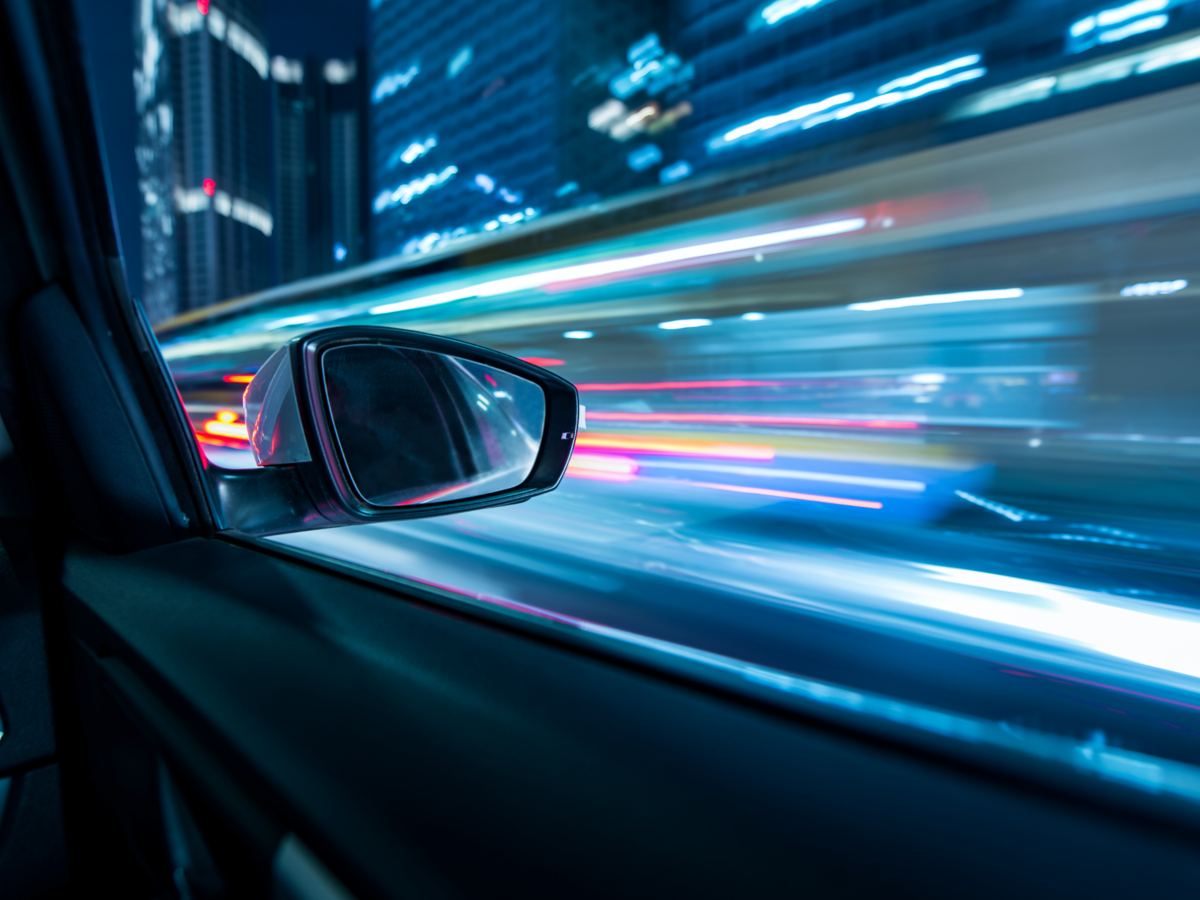 Heavy traffic flows both directions on a busy city highway in between high-rise buildings