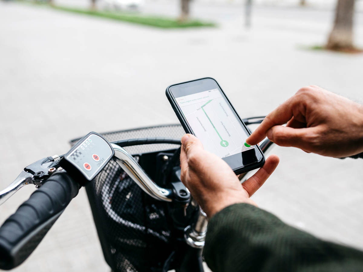 Man with e-bike using a smartphone for navigation