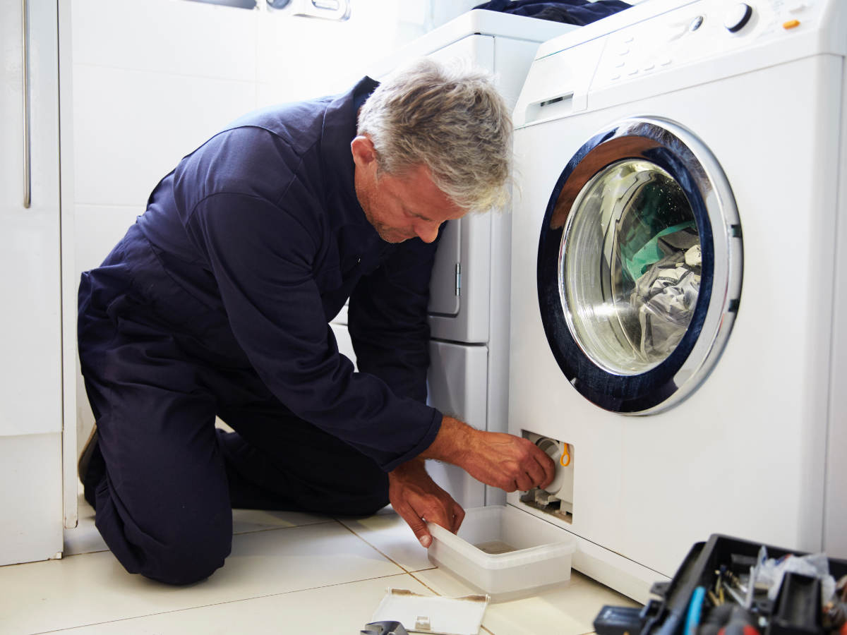 Repairman working on clothing dryer