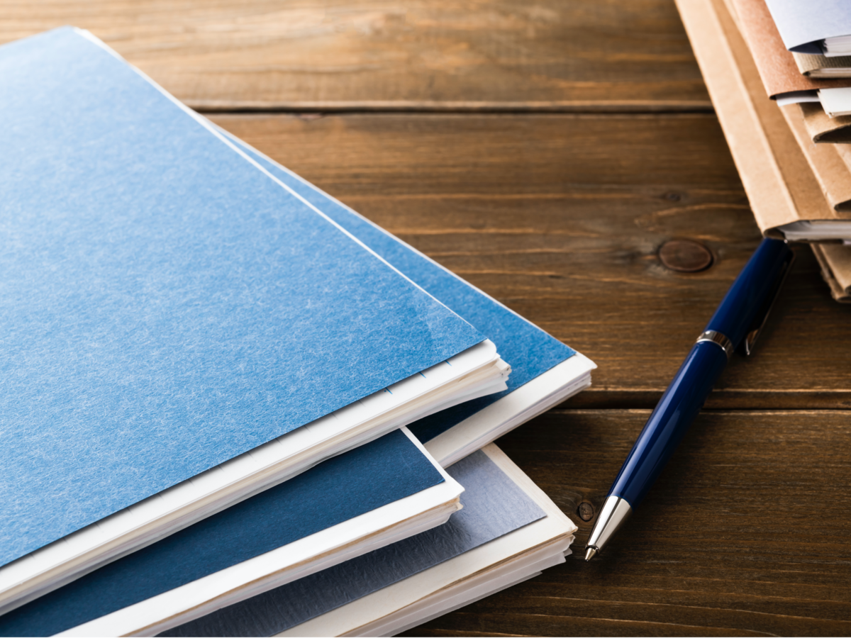 Notebooks and pen on a wooden table