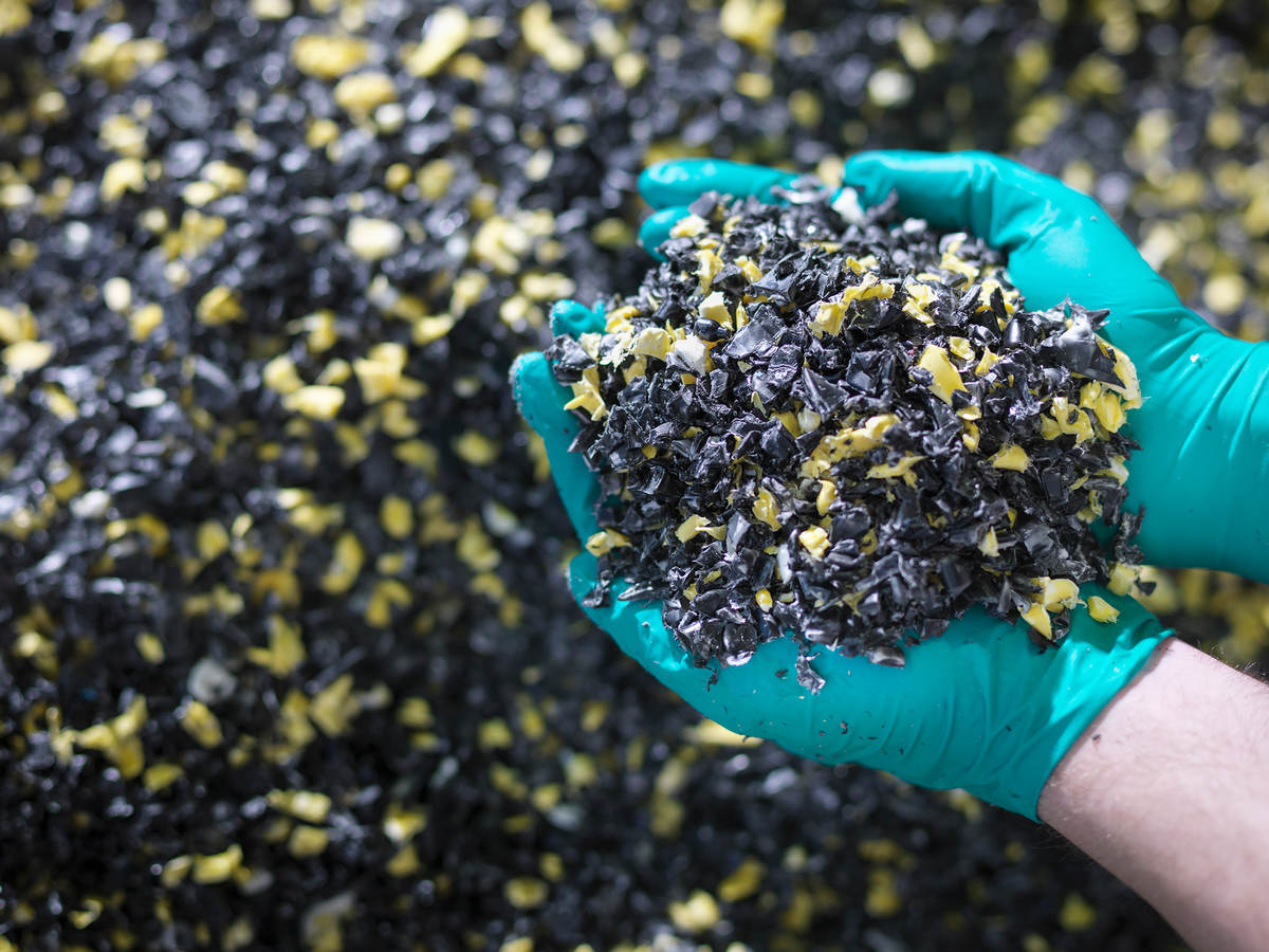 Worker holding recycled plastic in plastics factory