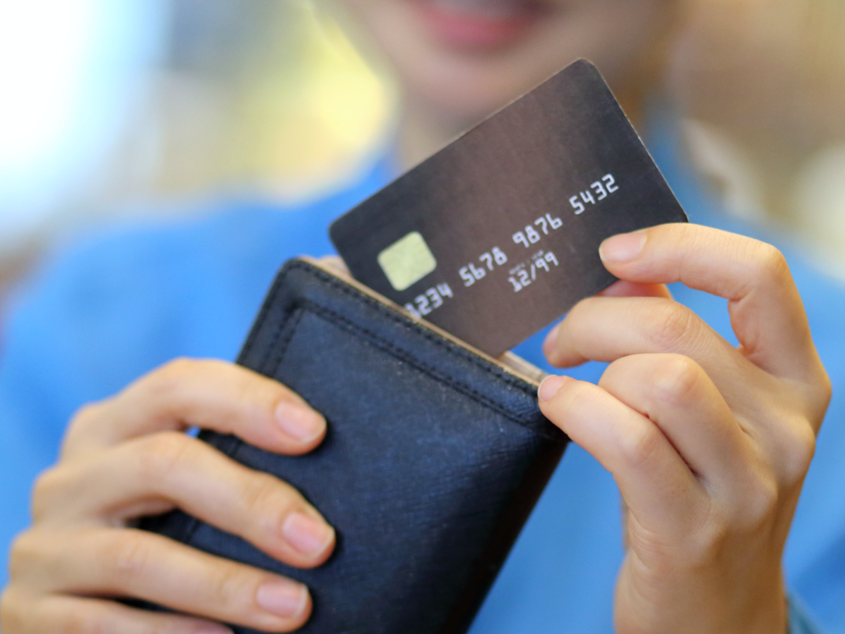 Woman pulling a credit card out of a wallet