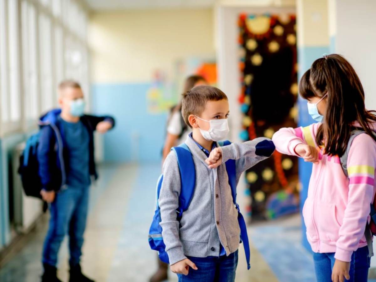 young students wearning masks and elbow bumping