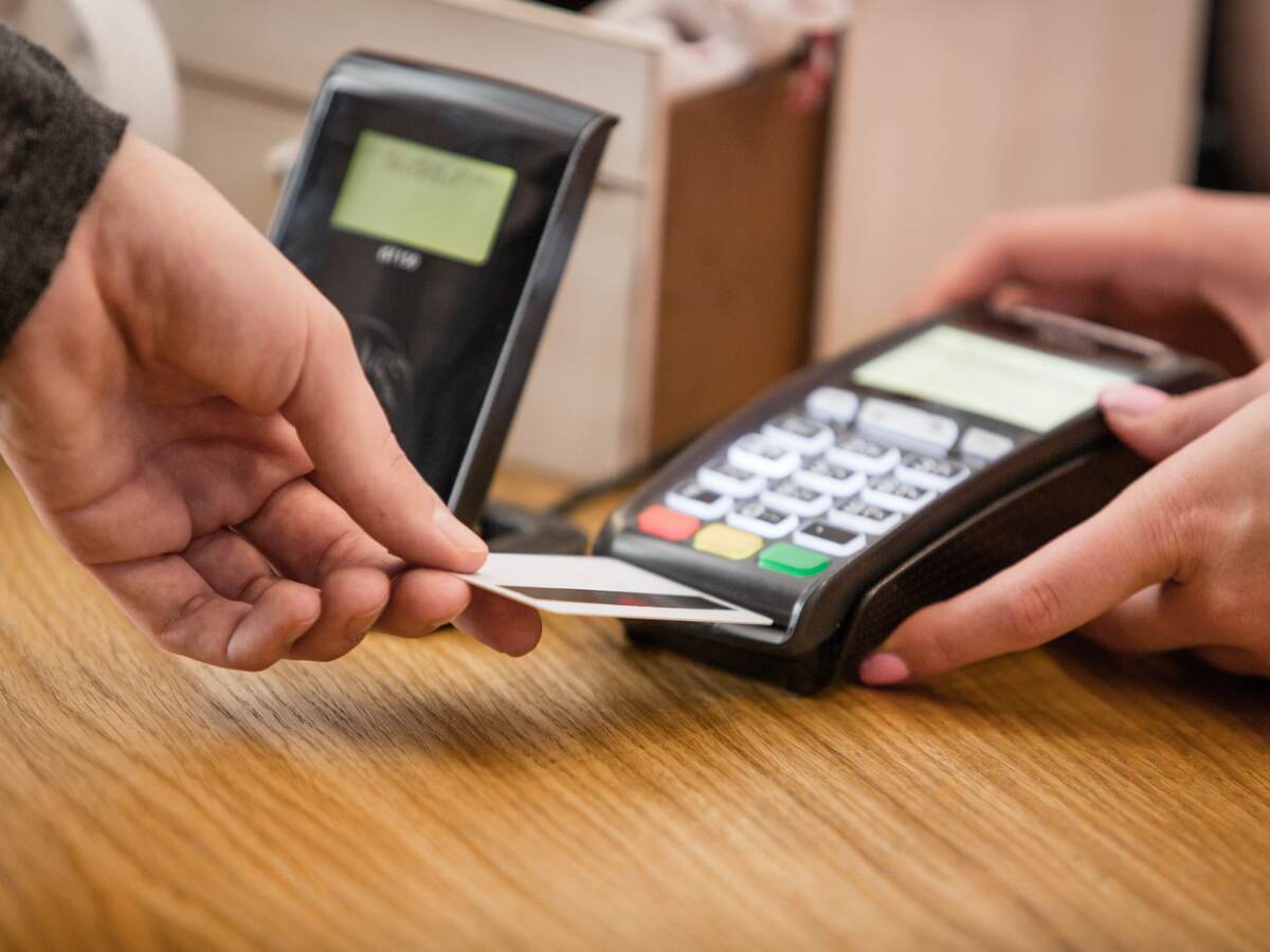 man inserting a credit card into a payment terminal