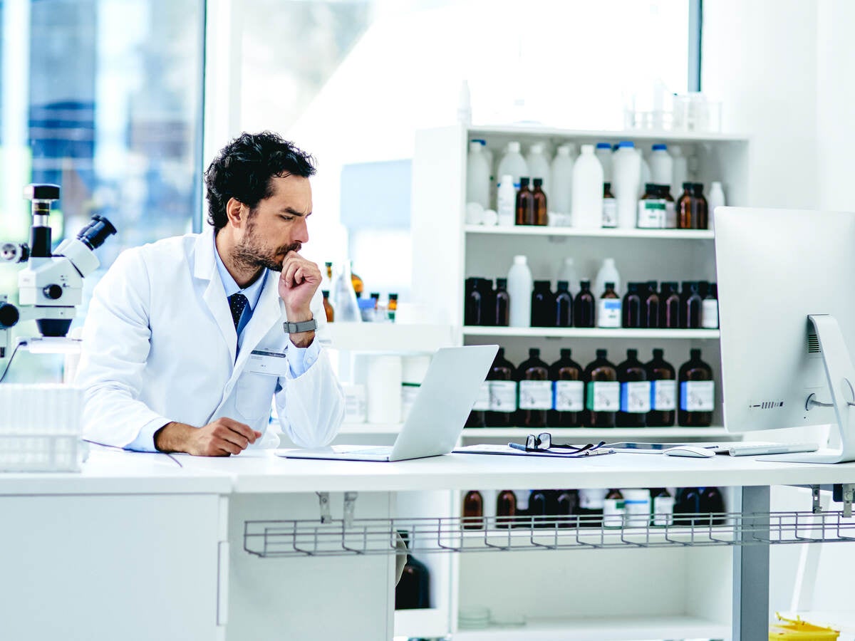 A doctor operates a computer in a laboratory setting.